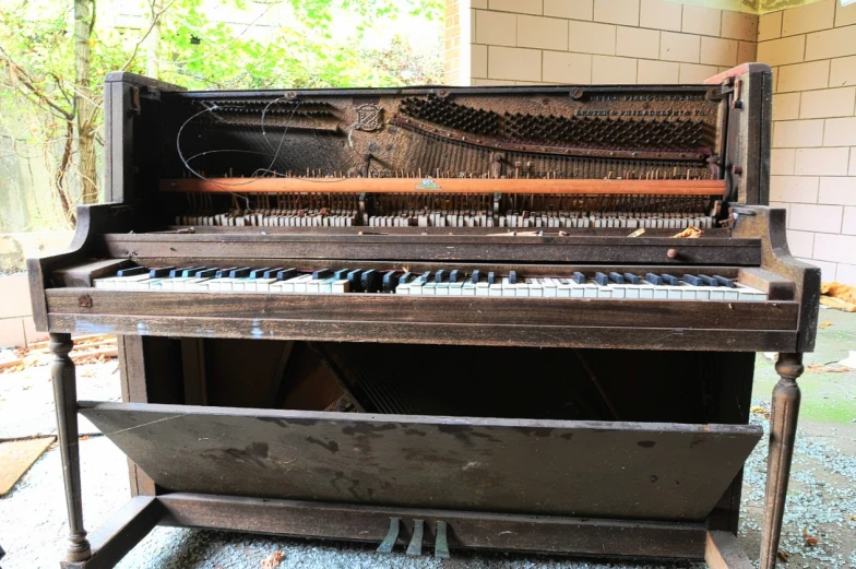 an old, rusty piano sitting on top of the floor