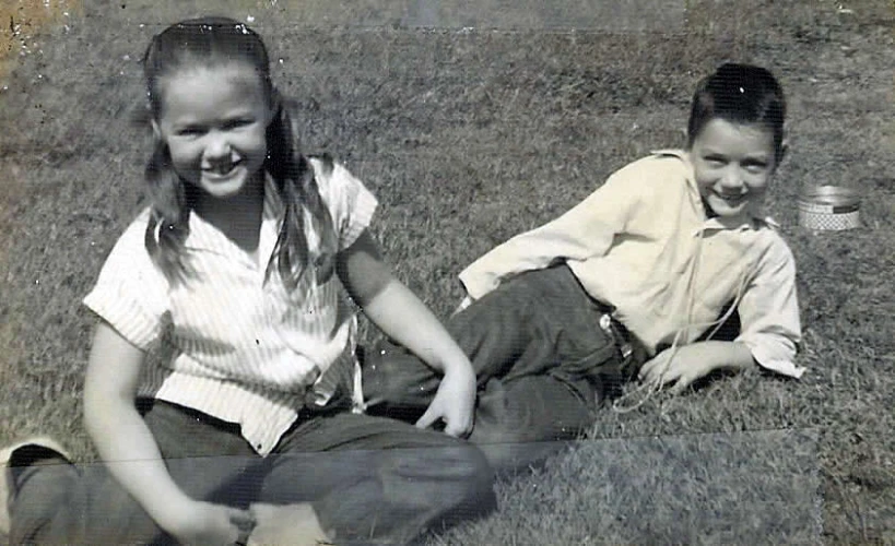 two children sitting on the grass smiling