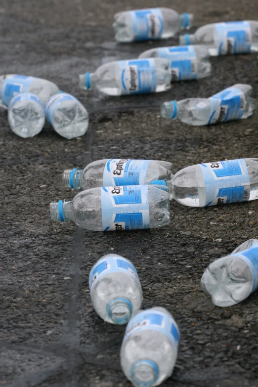 many empty water bottles are shown on the ground