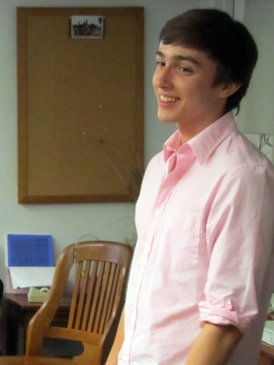 a person wearing a pink shirt and sitting at a desk