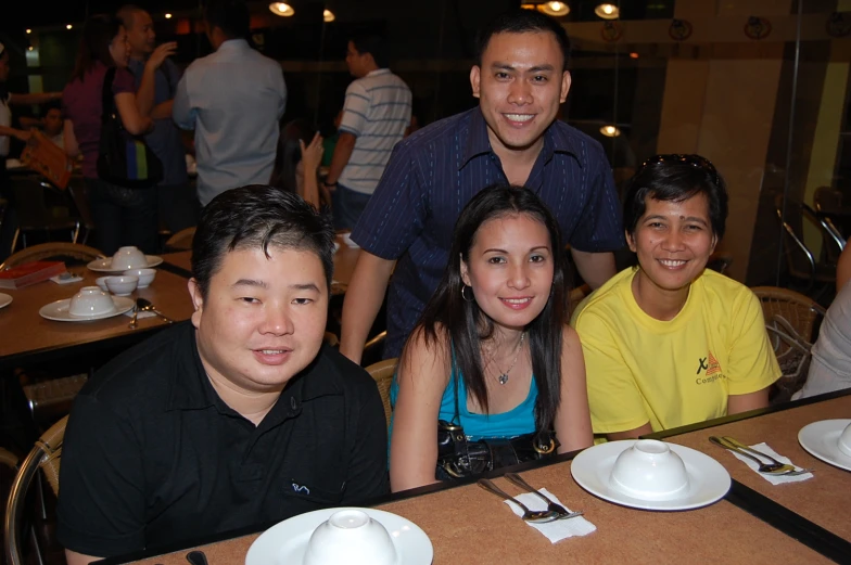 people are sitting at a table posing for a po