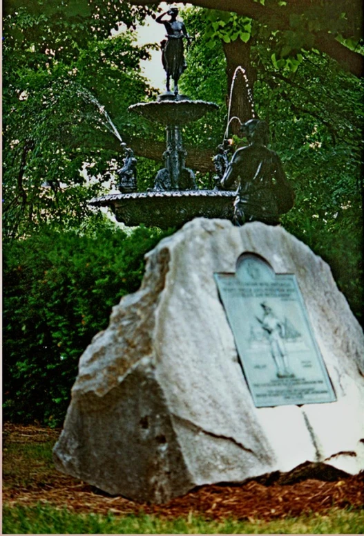 a stone monument with an angel statue standing near by