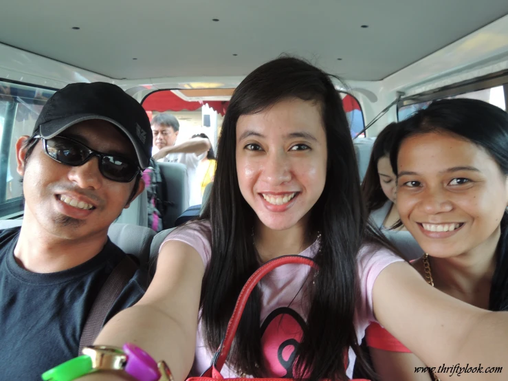 three people on a bus taking a picture