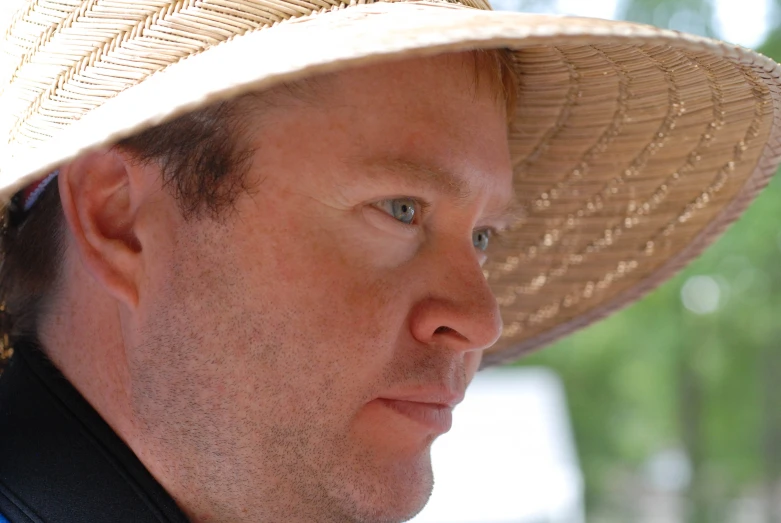 a close up of a man wearing a straw hat