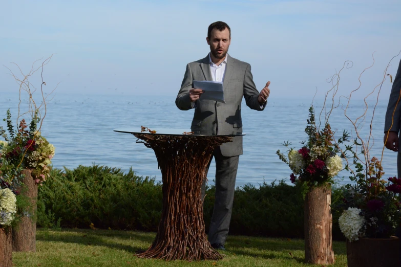 the man is standing in front of a big stump