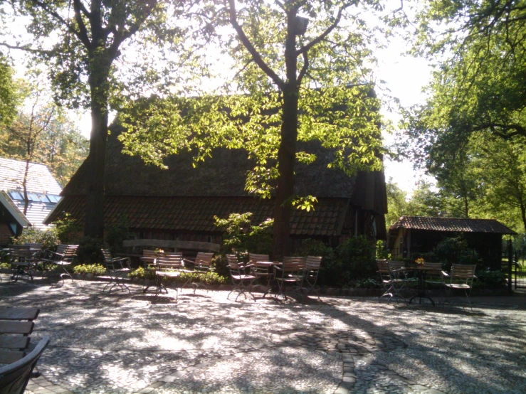 a sunlit area with lots of benches and tables