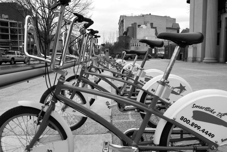 a long line of bicycles lined up on a city sidewalk
