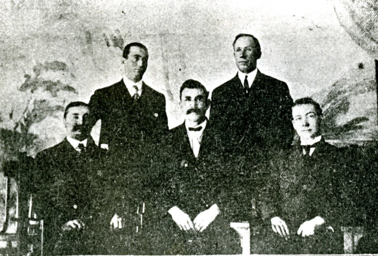 a group of men in suits and ties posing for a picture