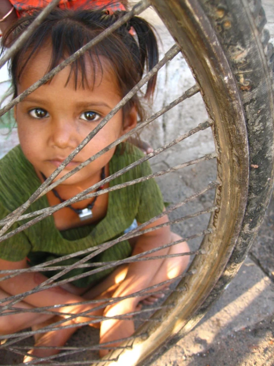 a little girl that is sitting down in a wheel