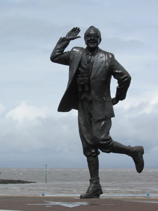 statue of man in coat, with gray sky background