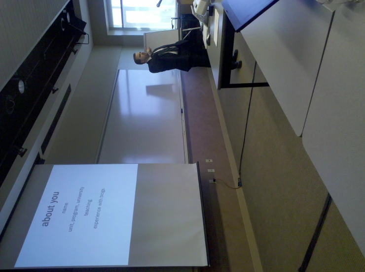 two people in a classroom watching a presentation on a projector screen