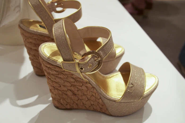 pair of gold colored sandals with metal straps on table