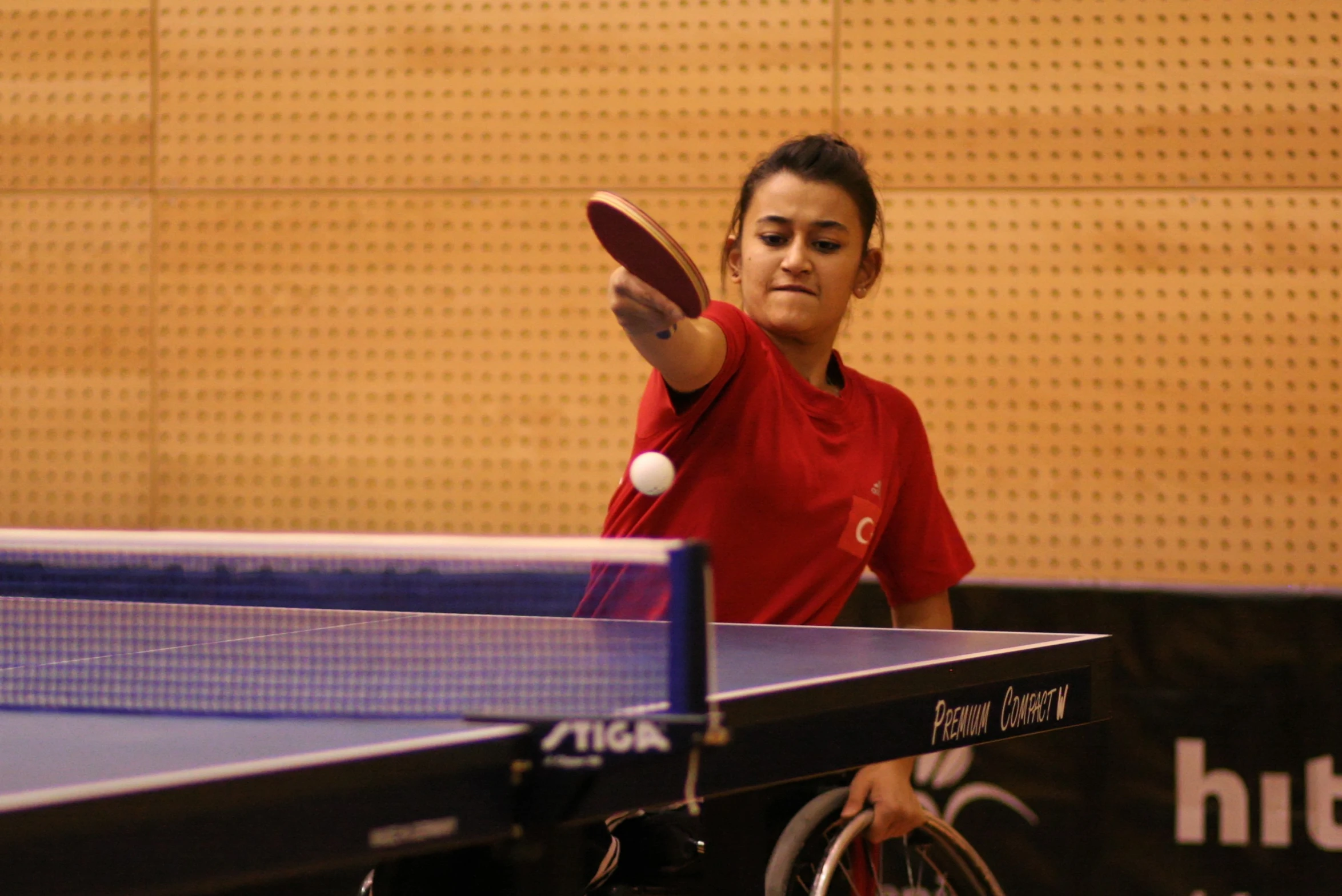 a woman throwing a ping pong ball in front of her