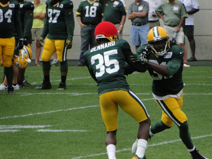 a football player jumps in the air while grabbing the ball