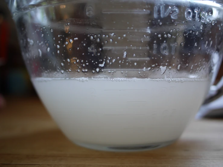 a measuring cup filled with water and some little white stuff