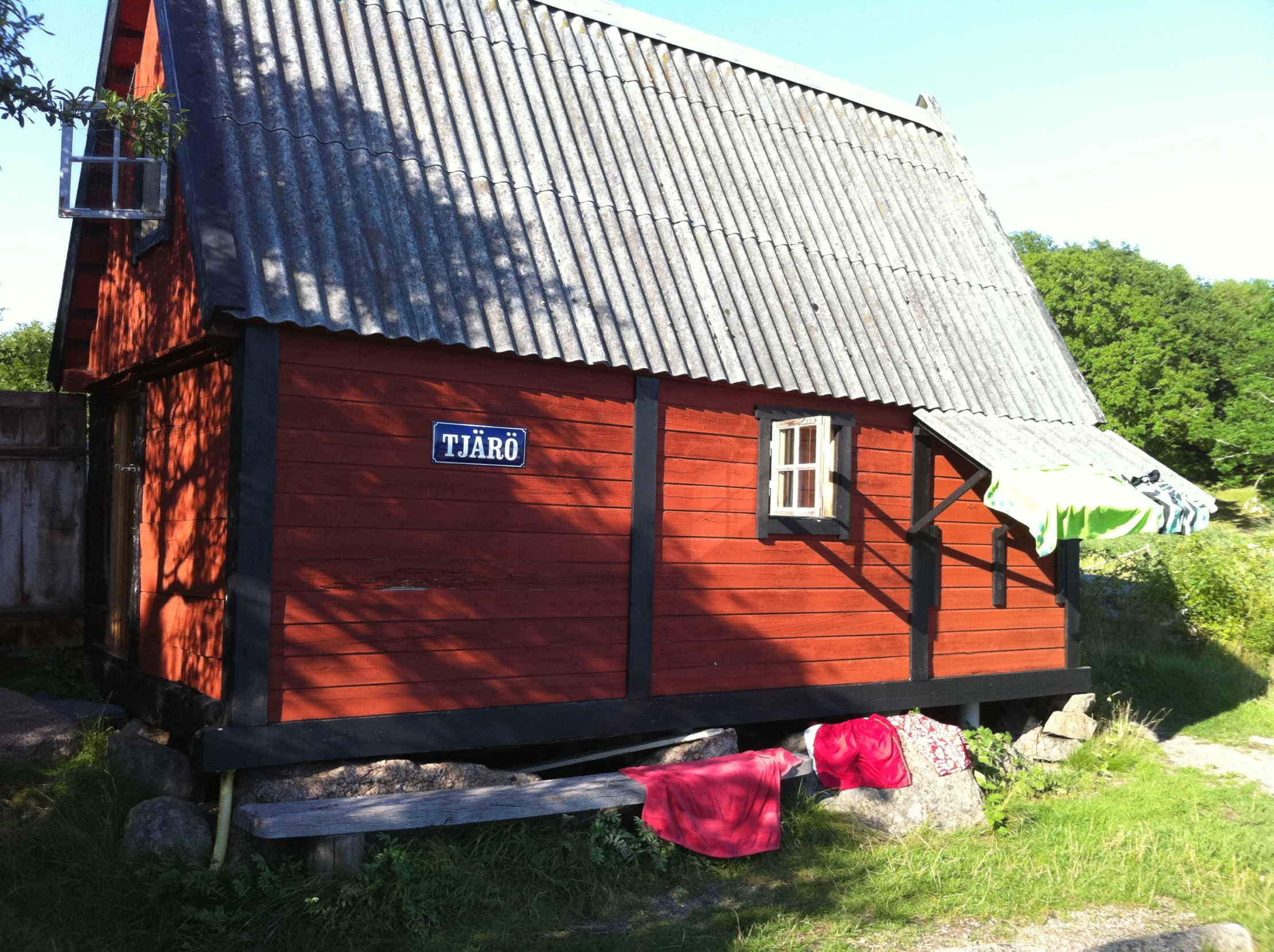 there is a small red cabin built on grass