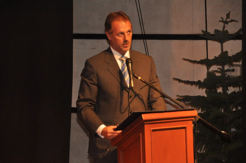 the man in a suit is giving a speech