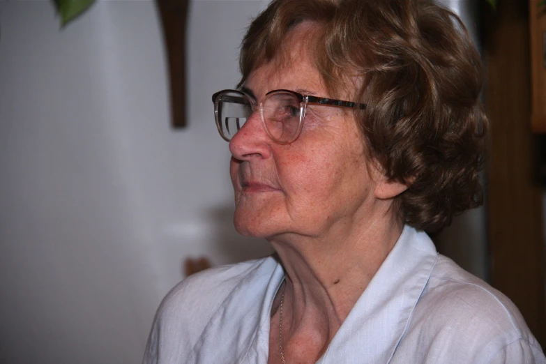 a woman in glasses is looking off into the distance