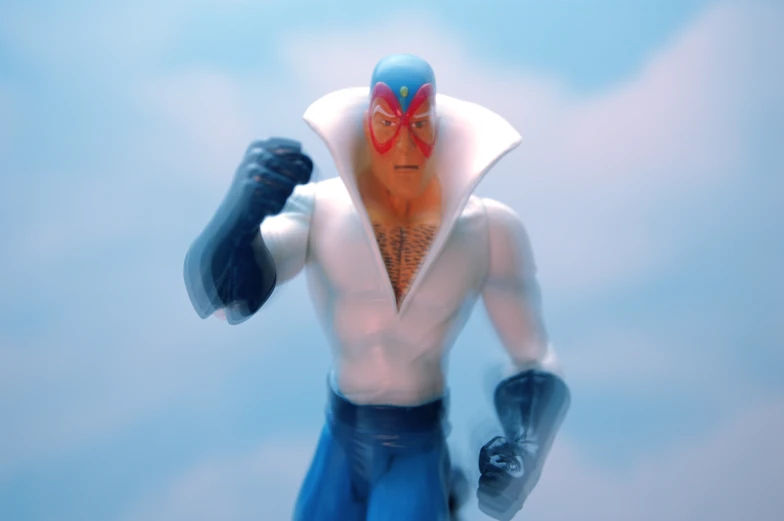 a toy with a hoodie and gloves in front of blue background