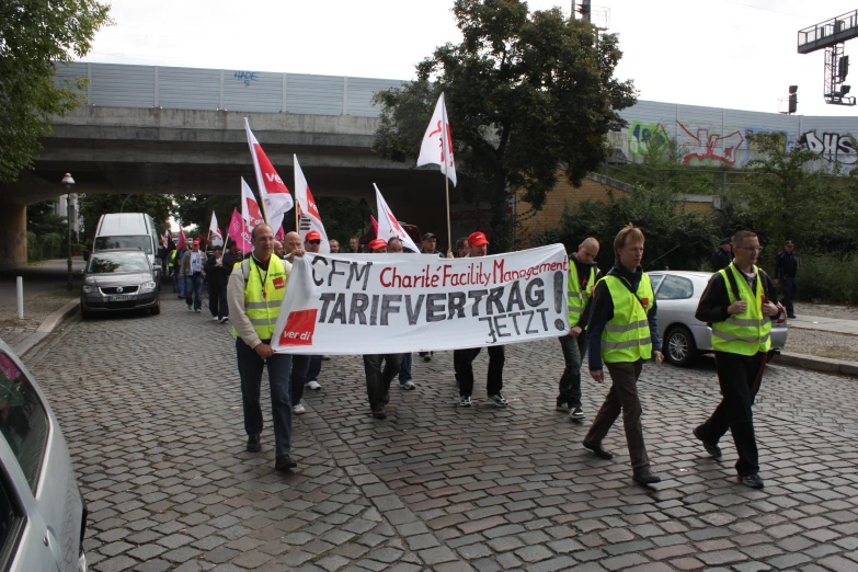 several people in vests carrying large flags