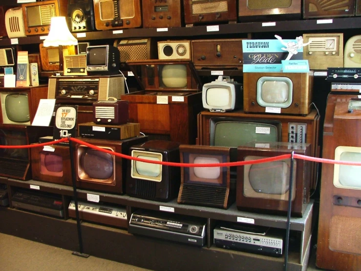 many old tvs sitting in a store display