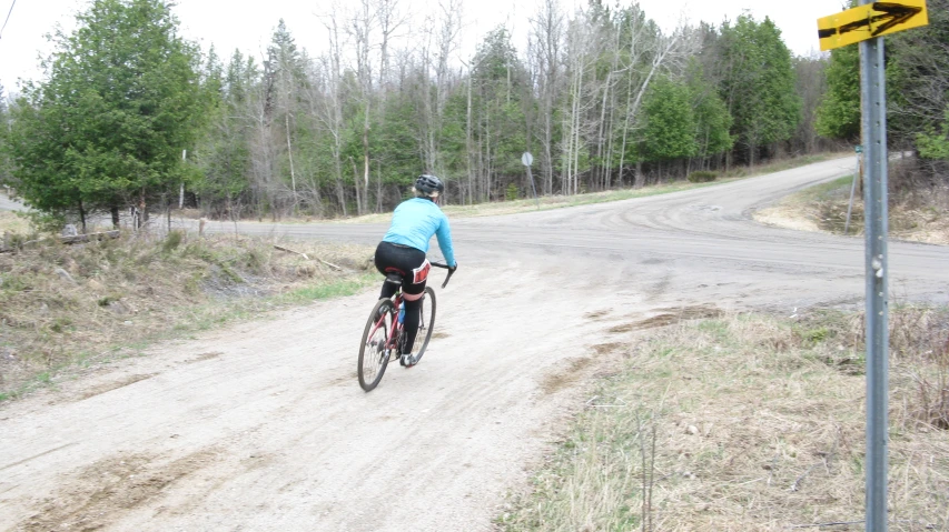 a person on a bicycle riding along the dirt road