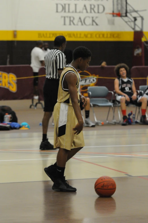 a group of boys play basketball inside a gymnasium