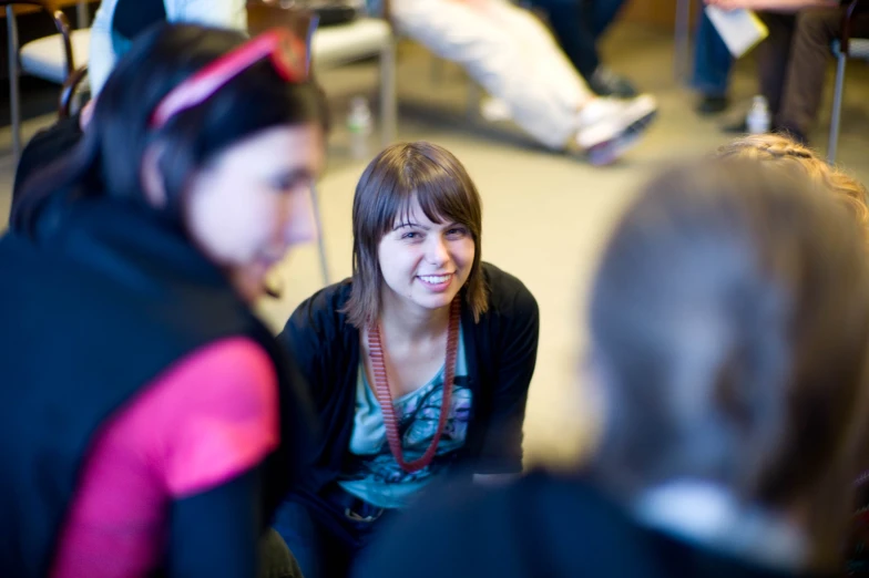 a young woman sits on the ground among a crowd