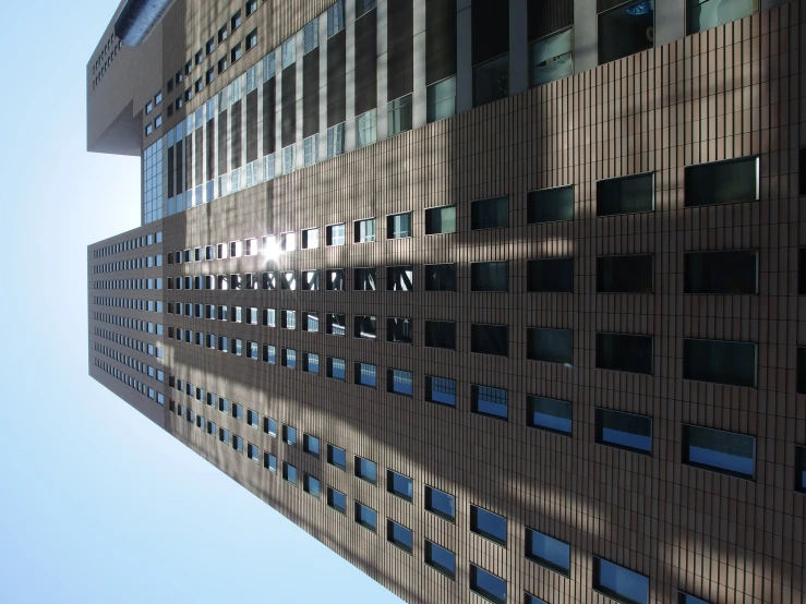 there is a tall brown building against the sky