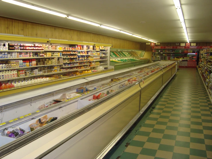 a row of supermarket shelvings with one aisle running through it