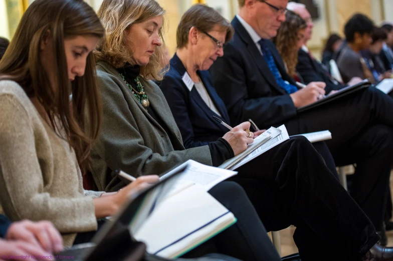 a large group of people sitting and studying