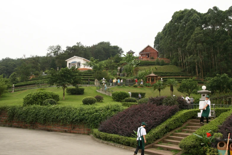 two people in front of some bushes at a park