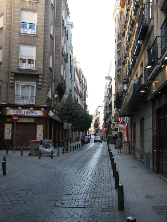 a narrow city street with buildings and cars on it