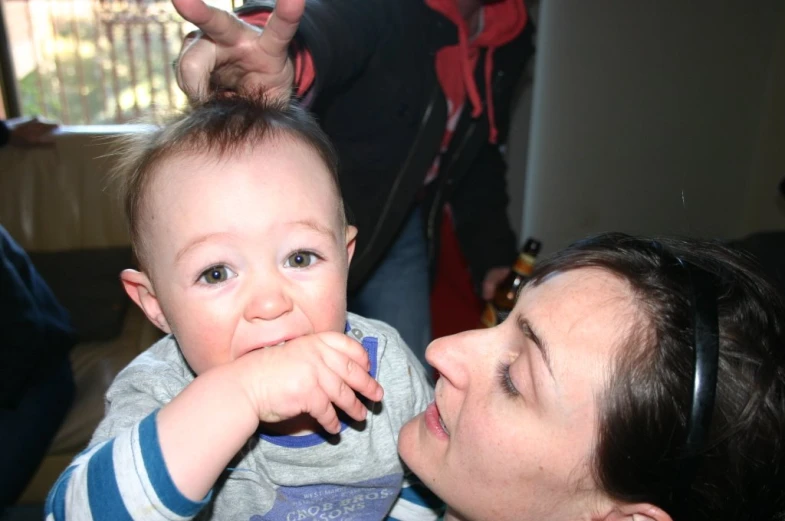 a woman holding a baby with headphones on