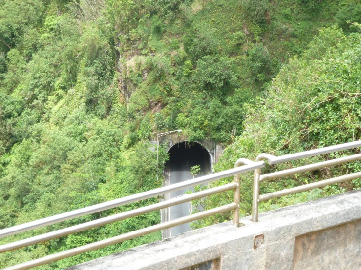 a man on the side of a highway is looking at a small tunnel