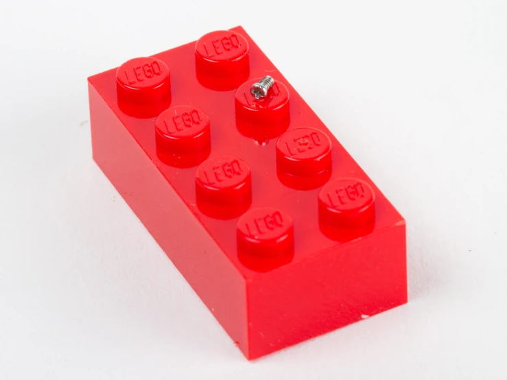 a red lego block has a metal ball in its middle