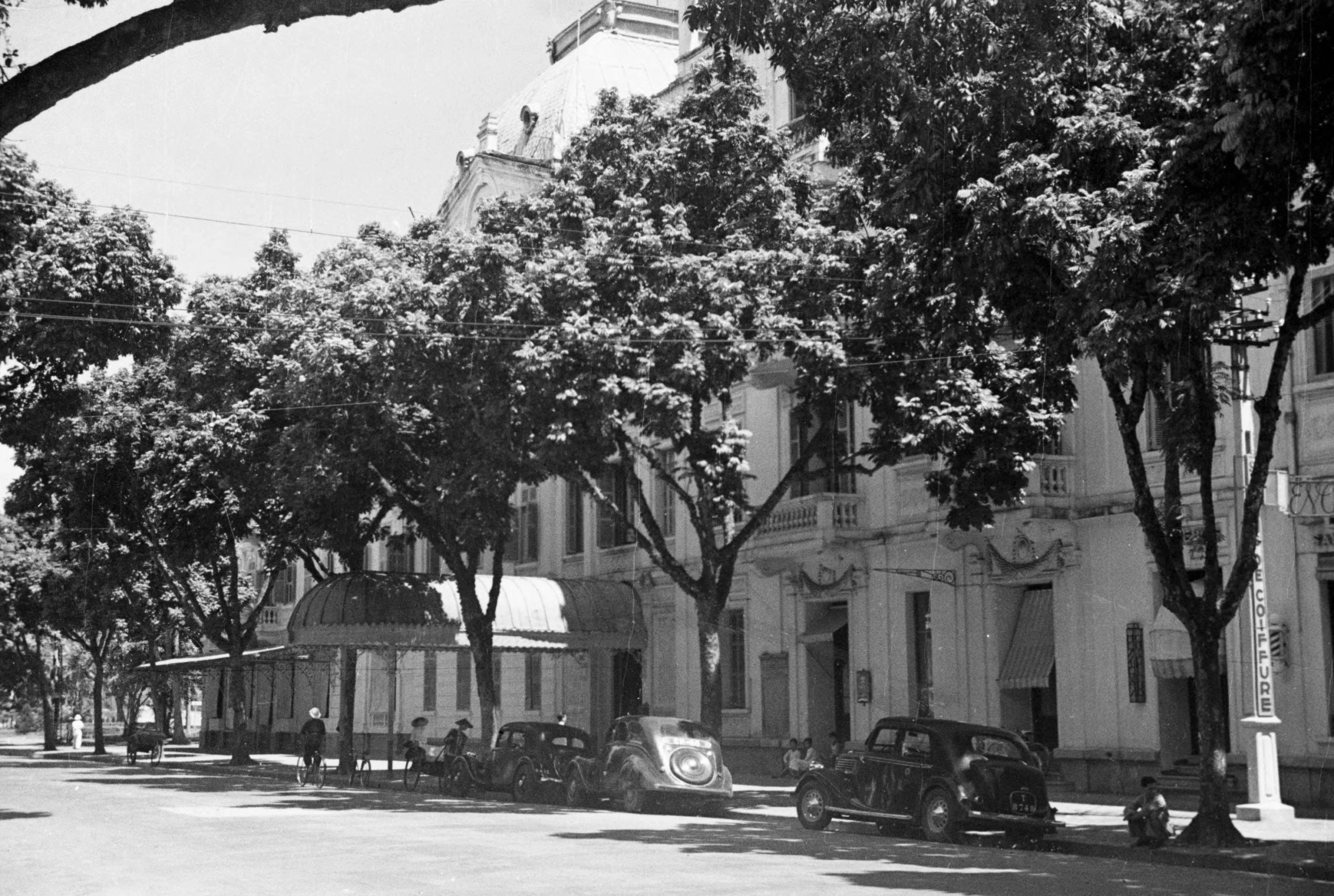 the corner with the flag on the building and trees all around