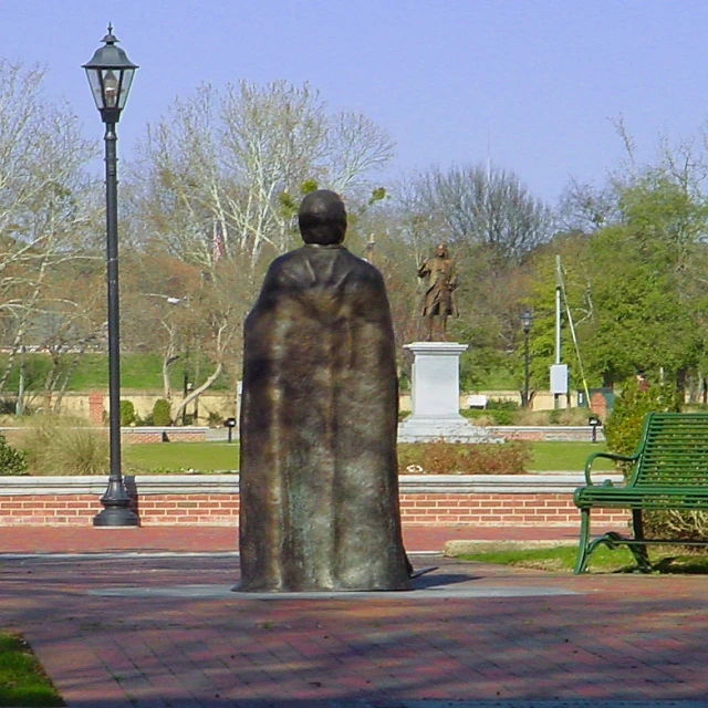 a statue that is standing by a bench