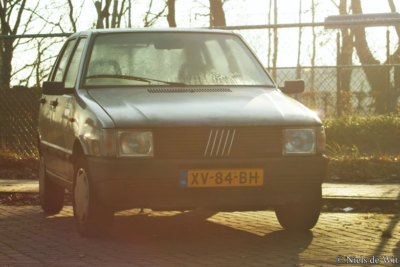 a volkswagen type car parked next to a wooden fence