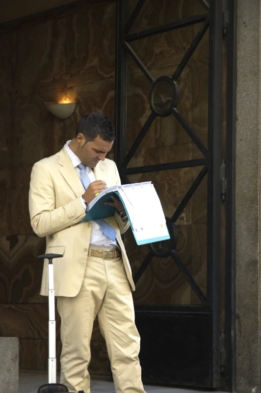 a man is reading a book by a building