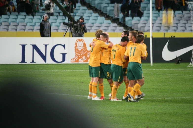 players in a group congregate on a soccer field