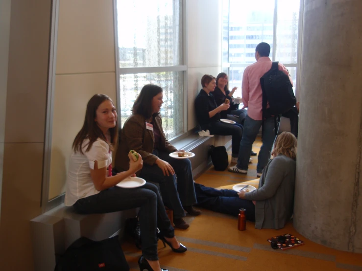 a group of women sitting and eating inside a building