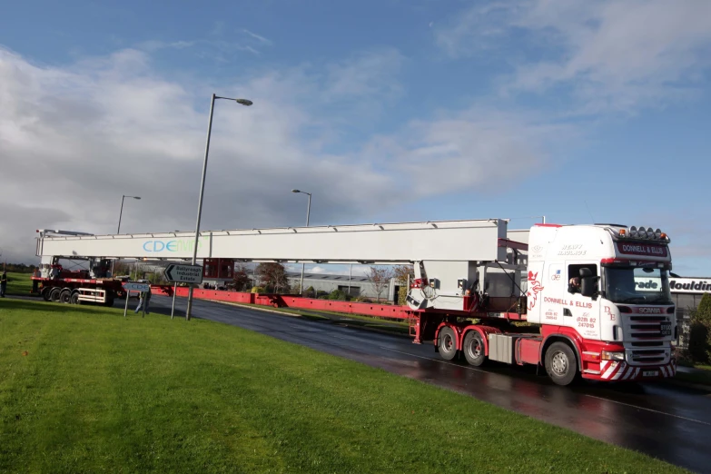 a red and white truck driving down a street