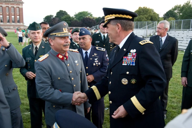 two men in uniforms shake hands with each other
