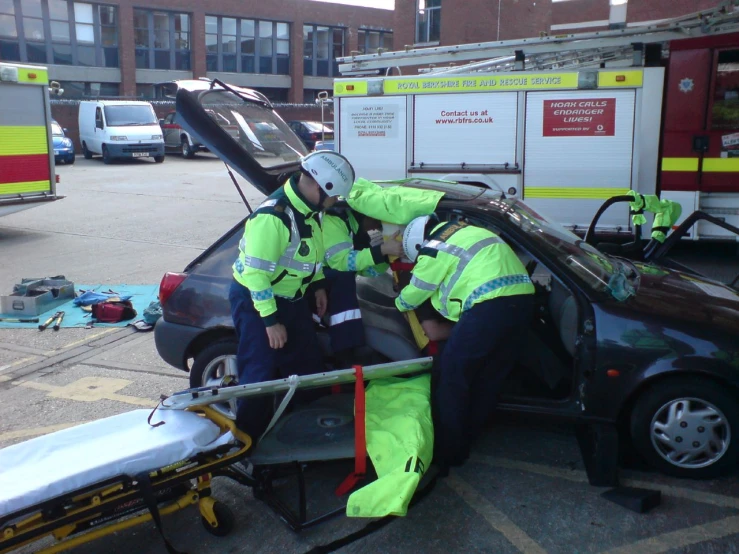 fire and rescue workers attach an emergency door to the inside of a car