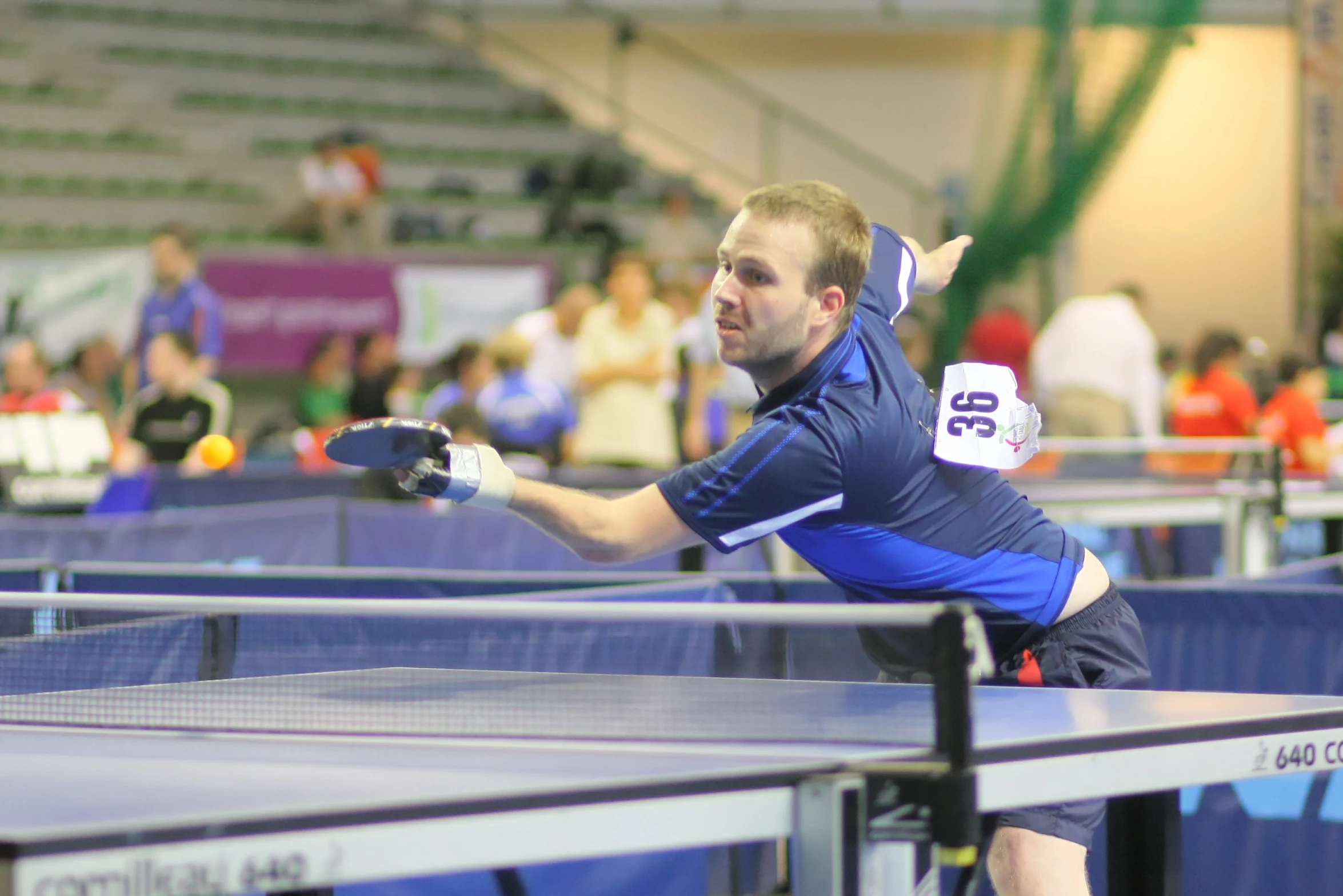 a person reaching up toward a ping pong table