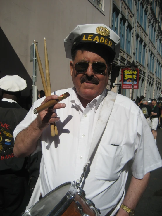 a navy man holding two drums and two sticks