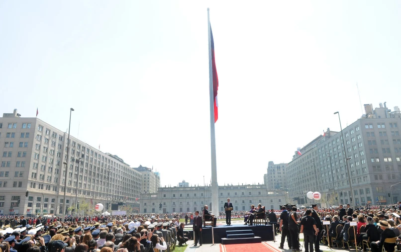 a large group of people and flags gathered on the grass