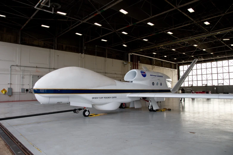 a small jet sits on display inside a hangar