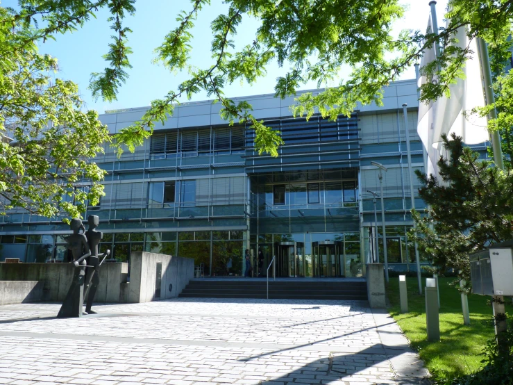 a building with a courtyard near many trees and flowers